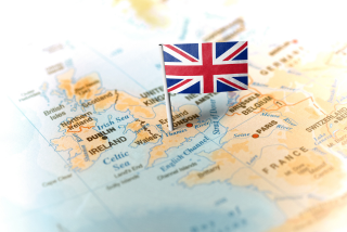 Mapa da Europa com destaque para o Reino Unido e uma pequena bandeira britânica fincada sobre Londres.